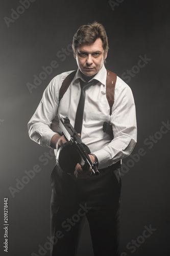 Handsome middle aged detective man with gun