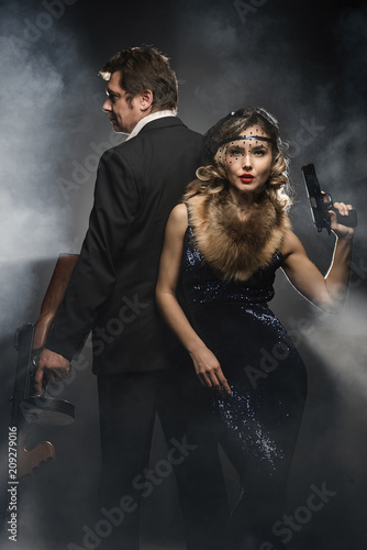 A pair of gangsters, a man and woman with guns