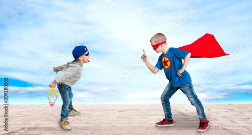 A boy in the costume of a superhero, teaches a little bully to the rules of good behavio	 photo