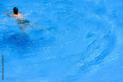 Man swimming in pool in summer