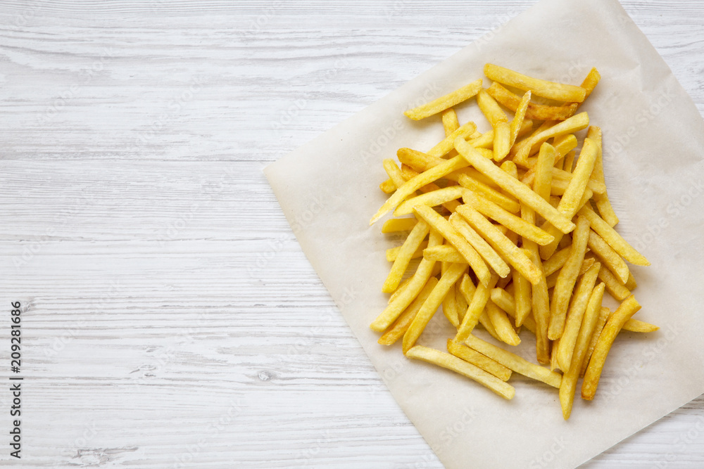 French fries over white wooden background, from above. Copy space. French fries over white wooden background, from above. Copy space.