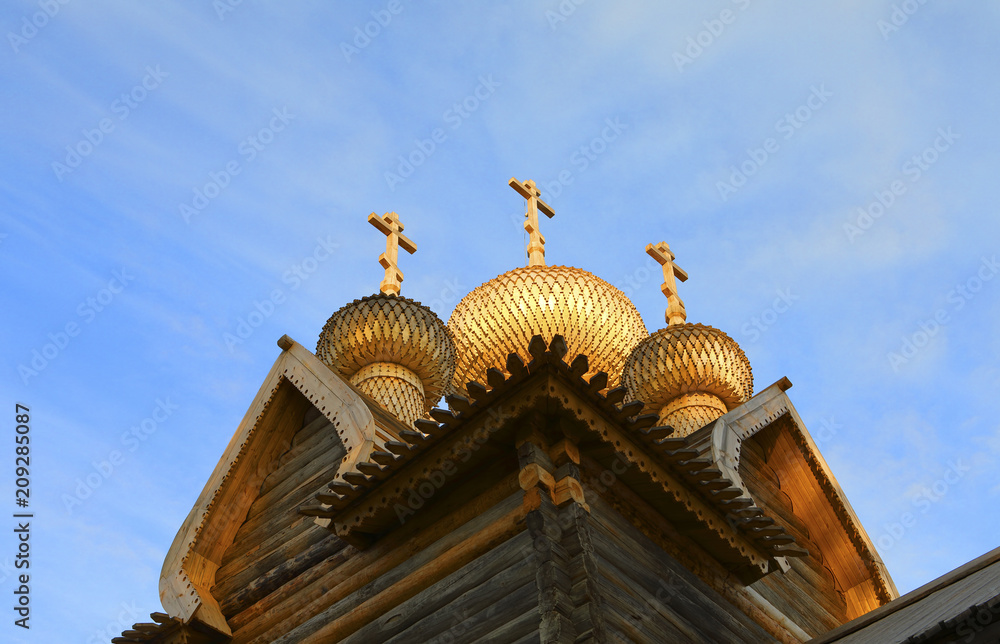 domes of wooden orthodox church in sunset light