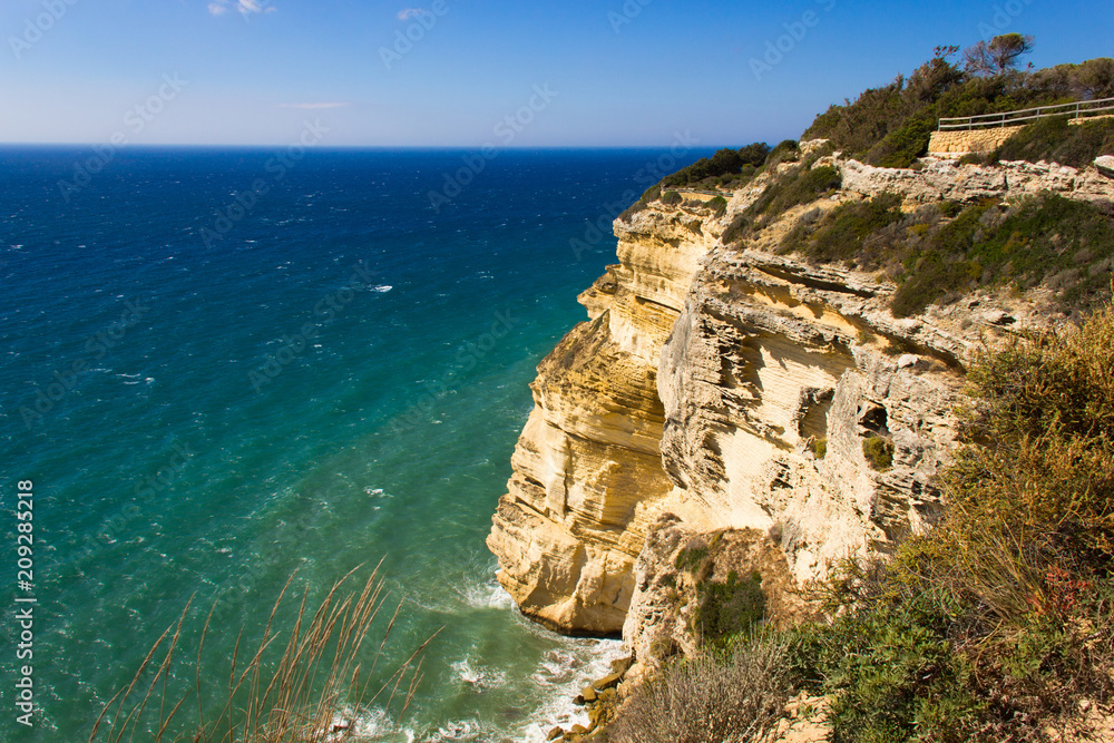 Impressive sand rock cliff by blue sea in nature park on sunny day in Cadiz, South Spain. Wild coastline landscape