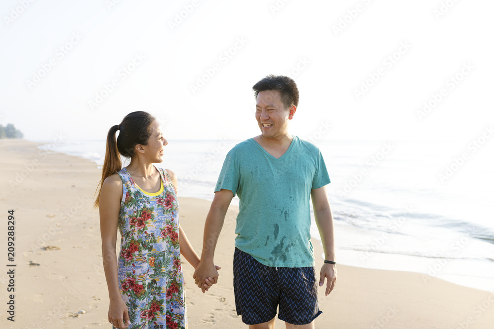 Asian couple holding hands at the beach Asian couple holding hands at the beach