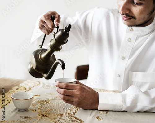 Muslim man having a cup of tea photo