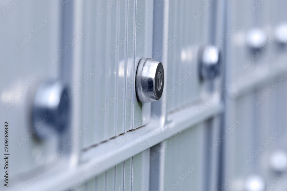 Real apartment mailboxes in metal at entrance of modern residential building. Close up of lock from mail boxes of metallic postal block. Modern and fancy mail system of an urban or rural residence. Real apartment mailboxes in metal at entrance of modern residential building. Close up of lock from mail boxes of metallic postal block. Modern and fancy mail system of an urban or rural residence.
