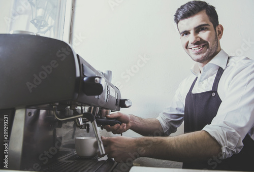 Barista prepares fresh coffee at coffee shop.