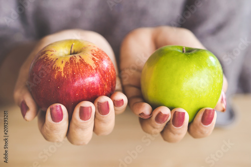 woman hand holding red and green apple fruit for diet  photo