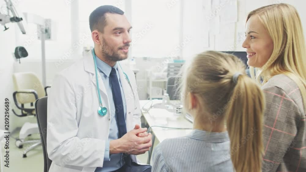 Low Angle Shot of Friendly Doctor Explaining How Medicine Works to a Cute Little Girl and Her Mother. Pediatrician Cures Little Girl. Modern Medical Office. Shot on RED EPIC-W 8K Helium Cinema Camera. Low Angle Shot of Friendly Doctor Explaining How Medicine Works to a Cute Little Girl and Her Mother. Pediatrician Cures Little Girl. Modern Medical Office. Shot on RED EPIC-W 8K Helium Cinema Camera.