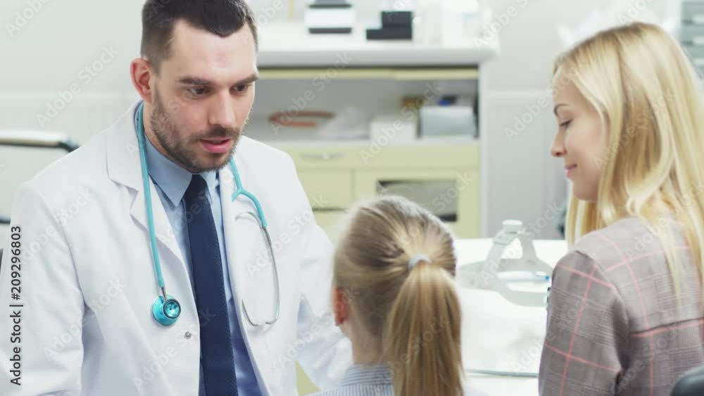 Friendly Medical Doctor Talks With Sweet Little Girl who came With Her Mother for an Appointment. Healthy Child With Happa Parent. Health Care Working. Shot on RED EPIC-W 8K Helium Cinema Camera. Friendly Medical Doctor Talks With Sweet Little Girl who came With Her Mother for an Appointment. Healthy Child With Happa Parent. Health Care Working. Shot on RED EPIC-W 8K Helium Cinema Camera.