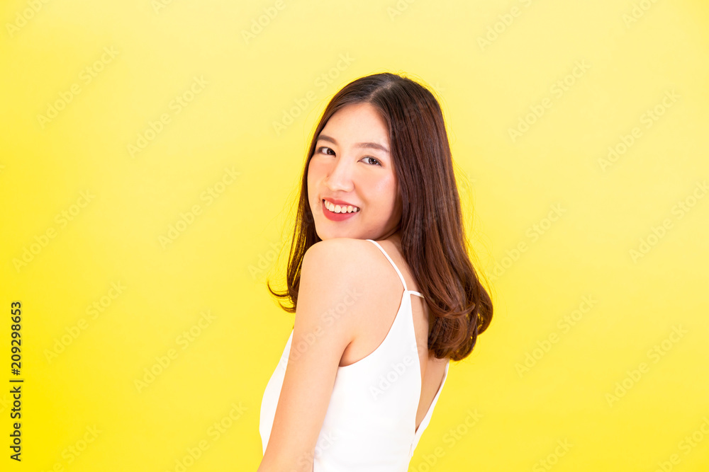 Portrait of attractive Asian smiling woman showing cute expression and posture with isolated on yellow background Portrait of attractive Asian smiling woman showing cute expression and posture with isolated on yellow background