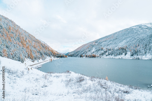 Winter landscape with lake. Beautiful landscape. Mountains covered by snow.