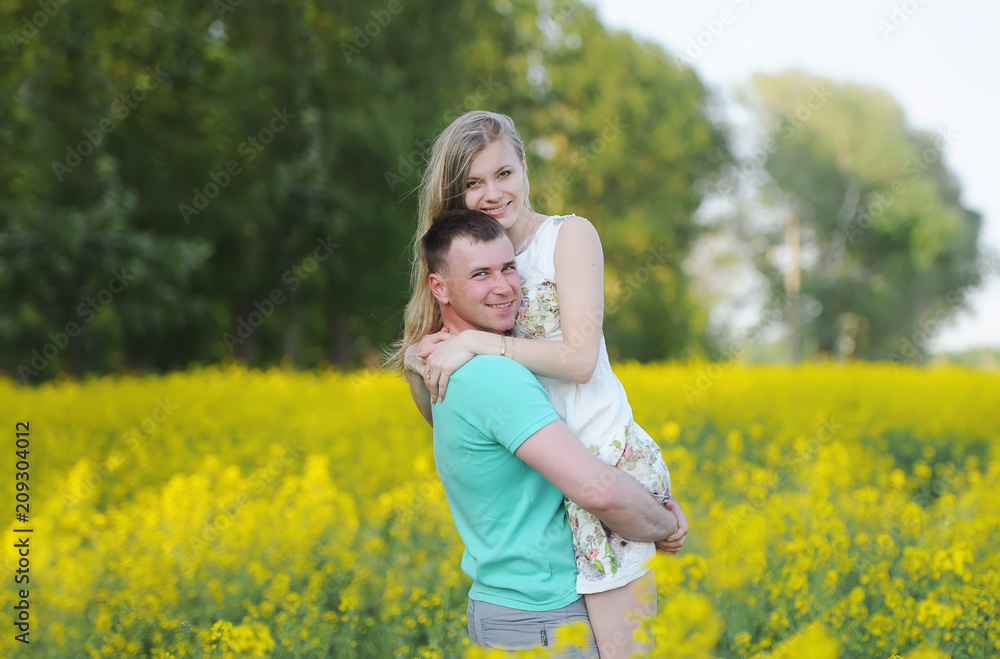 Happy young couple in love hugging in yellow colza field Happy young couple in love hugging in yellow colza field