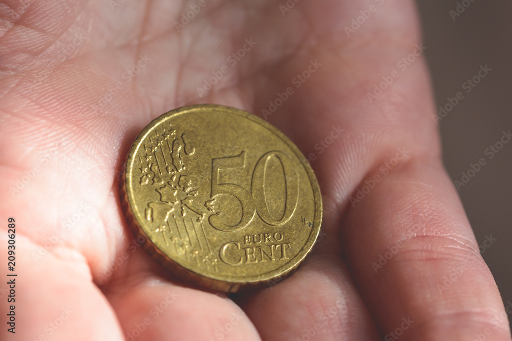 50 Euro Cent Coin in the palm of a female hands A 50 Euro Cent Coin in the palm of a female hands A