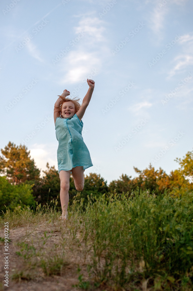 Fototapeta premium The girl runs joyfully with her hands up