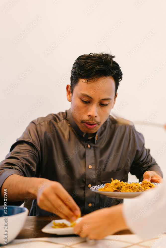 Portrait of a Malay Muslim man having a tasty breakfast meal with his wife at the dining table before Ramadan Portrait of a Malay Muslim man having a tasty breakfast meal with his wife at the dining table before Ramadan