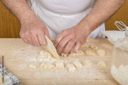 Chef italiano enseñando a cocinar gnocchi o ñoqui tradicionales de patata hechos a mano