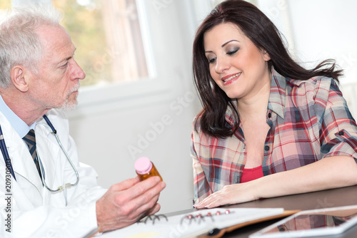 Senior doctor explaining medicine to female patient