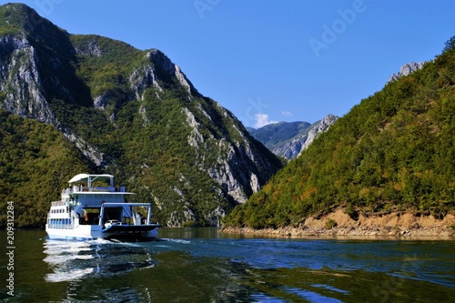 прогулочный корабль на реке среди гор photo