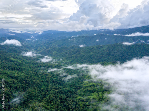 Aerial view of Mountain surrounded by clouds and fog, misty landscape with mountains and trees in the forest on rainy season. Amazing nature landscape.