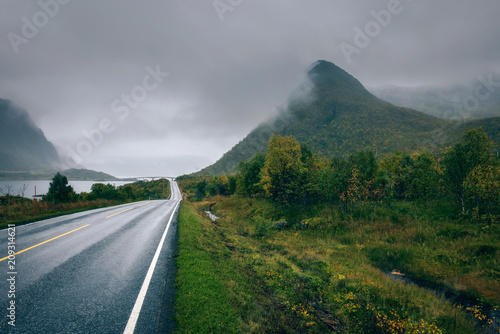 Scenic road along the coastline in Norway on a rainy and foggy day