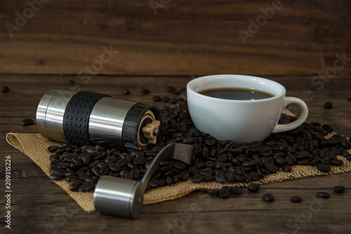 still life photo of hot coffee and coffee beans on the wood table 