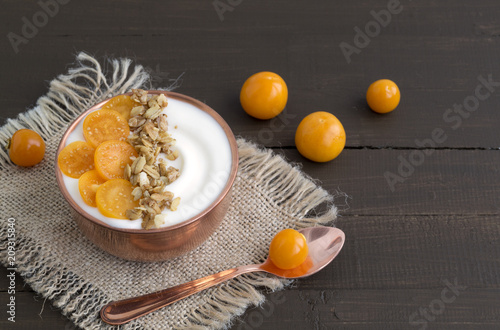 Natural homemade yogurt with ground-cherry on a wooden table.