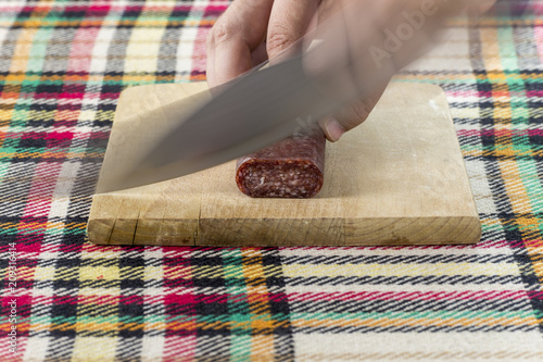 Cutting bulgarian flat sausage called lukanka photo