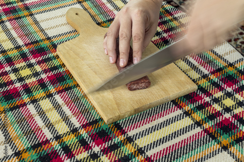 Cutting bulgarian flat sausage called lukanka photo