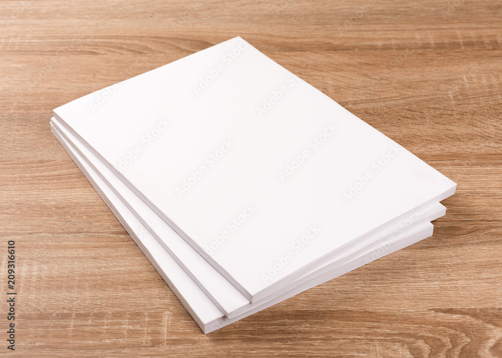 White blank magazines,book,brochures on wood table background. White blank magazines,book,brochures on wood table background.