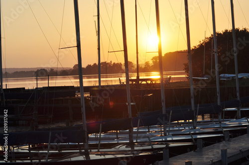 Ein kleiner Bootshafen am See bei Sonnenuntergang, Schiffe liegen vor Anker  photo