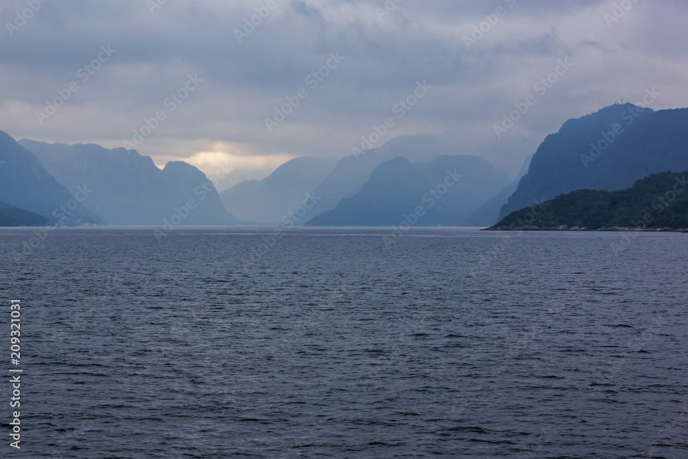 View of a norwegian Lysefjord surrounded by high mountains and clouds, Rogaland, Norway