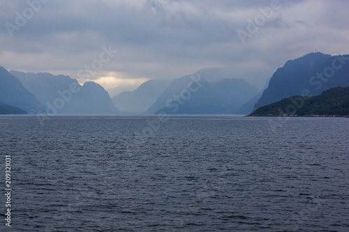 View of a norwegian Lysefjord surrounded by high mountains and clouds, Rogaland, Norway