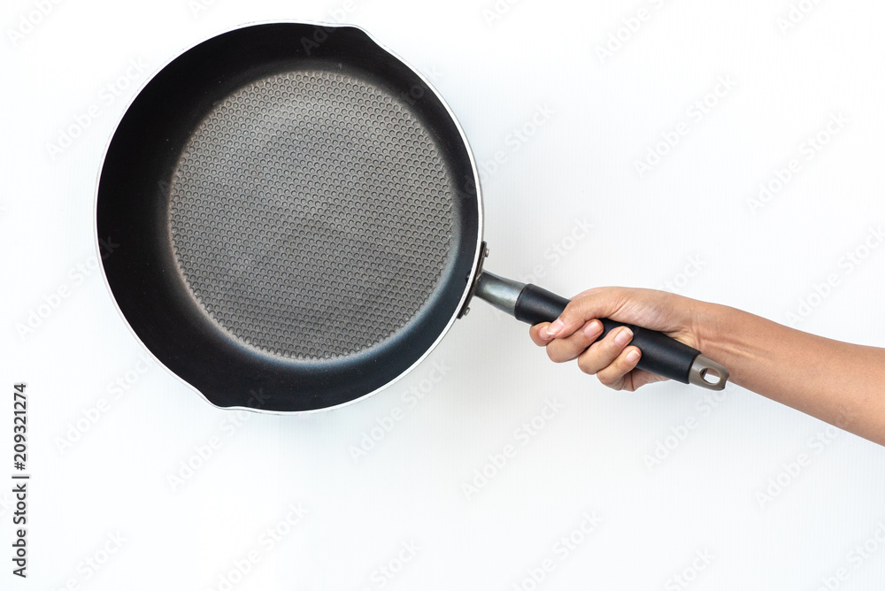 Woman hand holding flying pan on white background. Woman hand holding flying pan on white background.