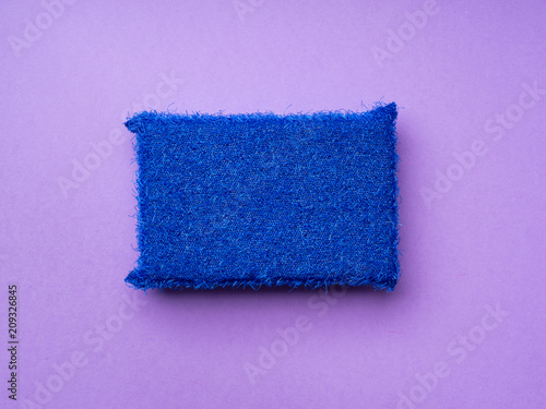 Cleaning sponge on purple background. Minimal cleaning concept