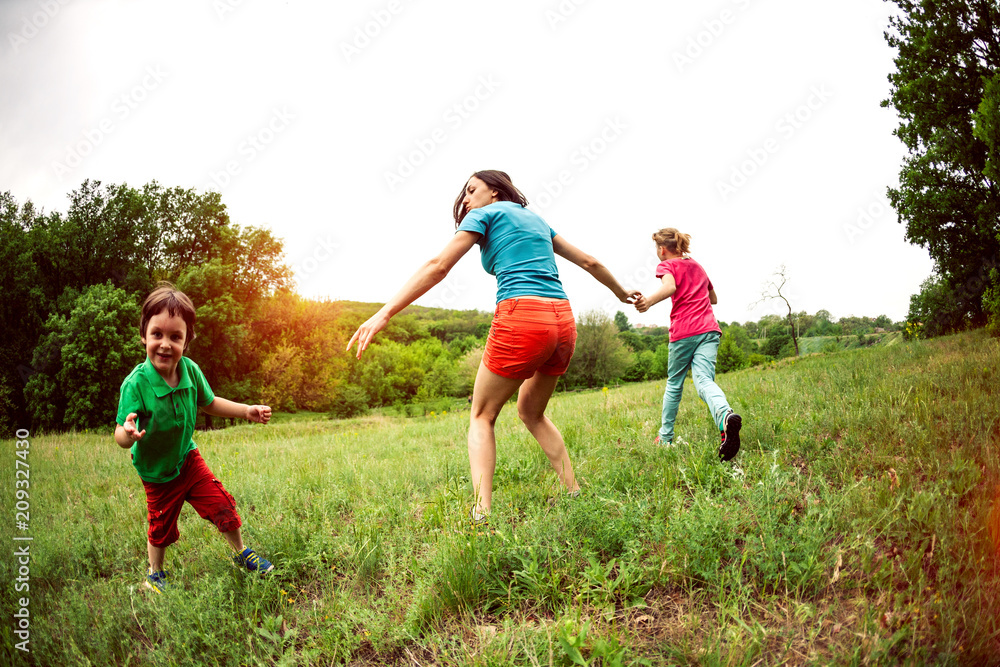 Children walk with their mother across the field. Children walk with their mother across the field.