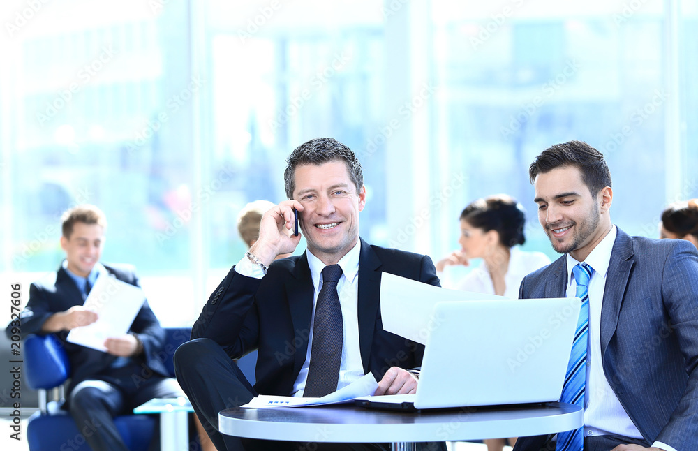 serious businessman talking on mobile phone sitting at your Desk serious businessman talking on mobile phone sitting at your Desk