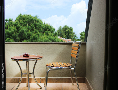 View from the balcony. A chair and a table close-up on the balcony overlooking the street. Place for recreation
