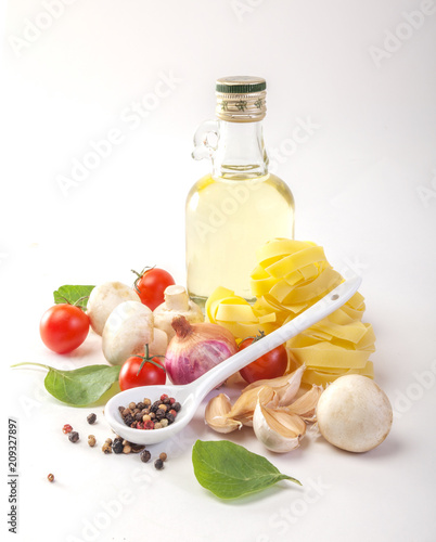 Pasta spaghetti with tomatoes, olive oil and spinach on a white background