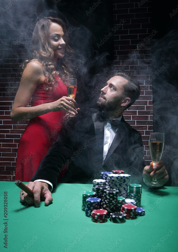 Couple in the casino playing poker on green felt Couple in the casino playing poker on green felt