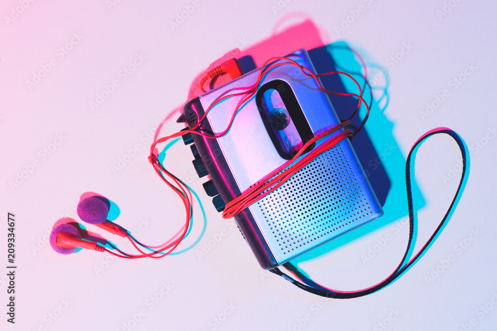 toned picture of retro cassette player and earphones on tabletop