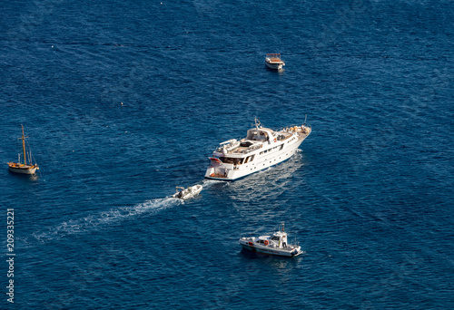 Ferry boat passes fishing boats moored in Tyrrhenian Sea near Positano Italy