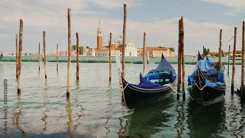 The symbol of Venice is the traditional gondola boat. Rock on the waves, moored near the shore