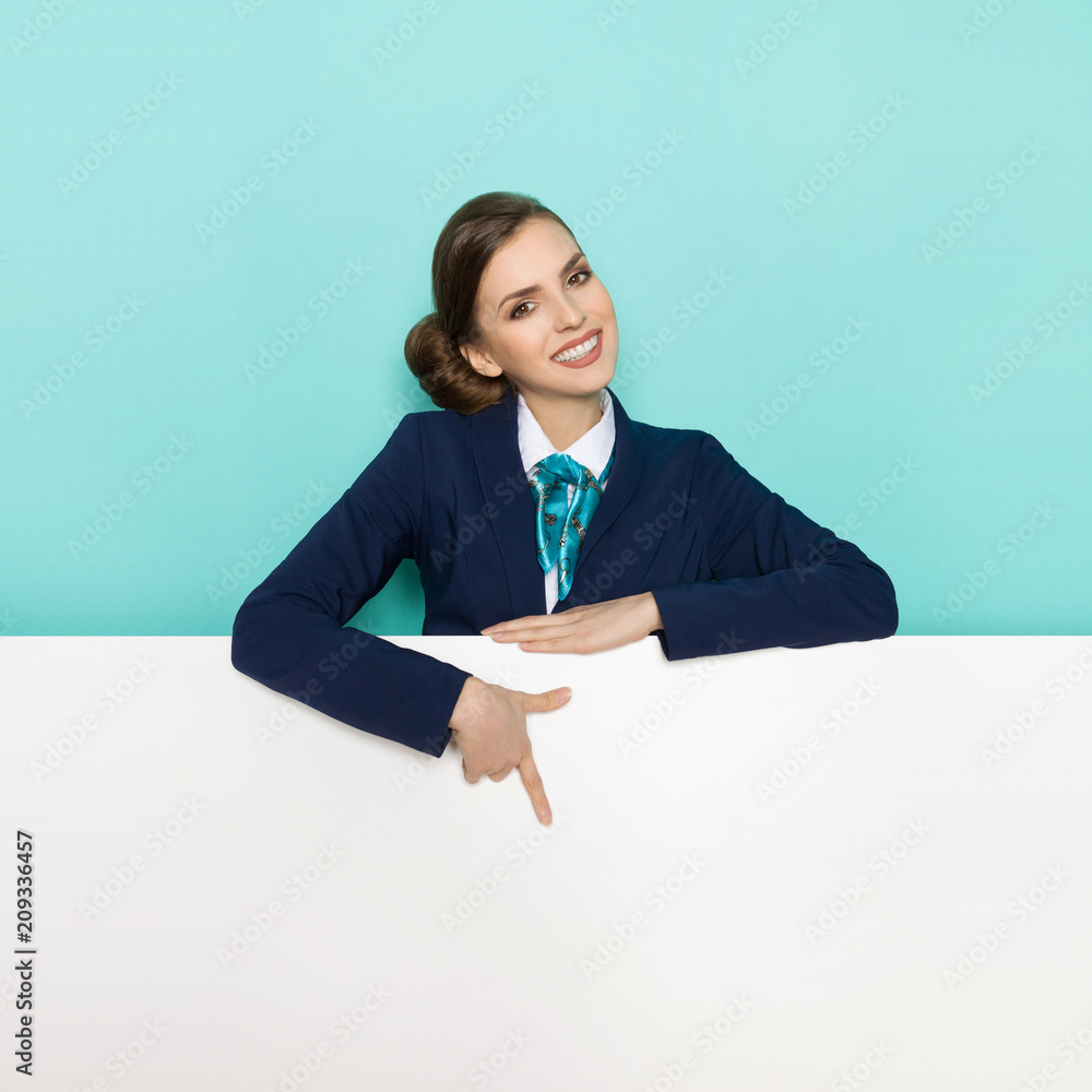 Woman In Blue Suit Is Standing Behind Banner, Smiling And Pointing Woman In Blue Suit Is Standing Behind Banner, Smiling And Pointing