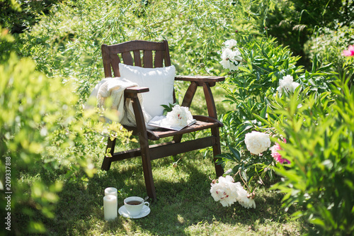 Fotografiet a wooden chair in the garden and a cup of tea