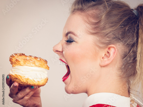 Obraz na plátně Funny woman holds cream puff cake