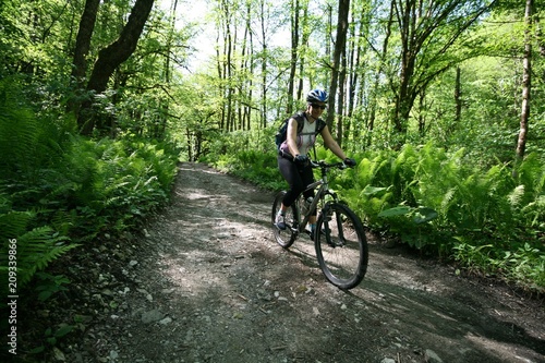 Girl on a bike riding on a forest road
