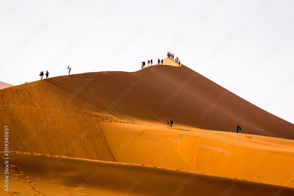 Tourists climbing sand dune Sossusvlei Namibia