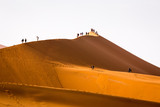 Tourists climbing sand dune Sossusvlei Namibia