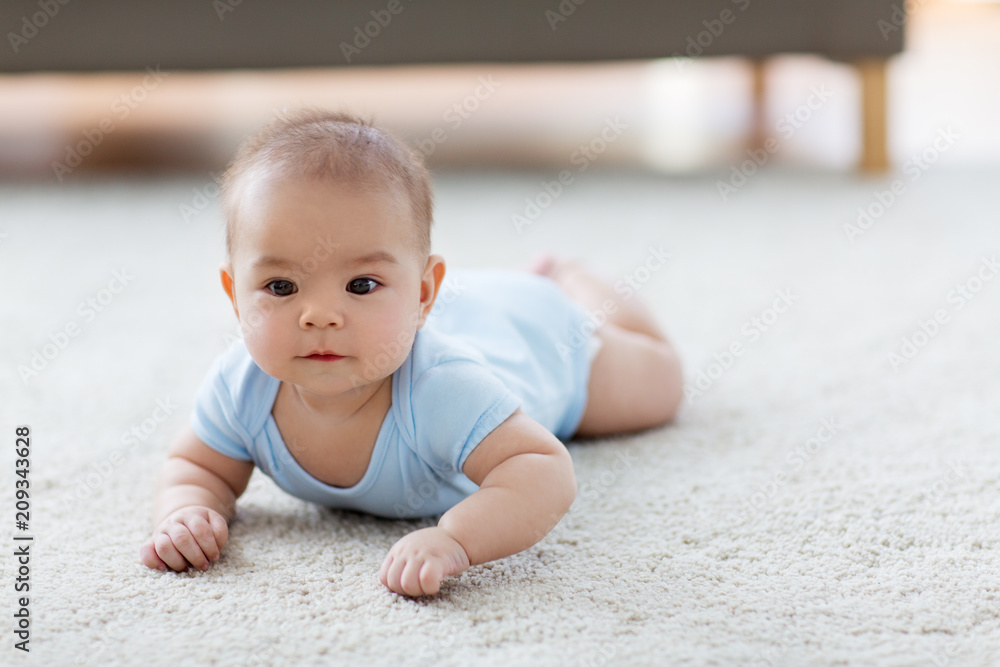 babyhood, childhood and people concept - sweet little asian baby boy lying on floor babyhood, childhood and people concept - sweet little asian baby boy lying on floor